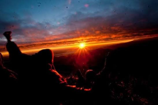 Viajeros observando el amanecer sobre las montañas andinas en septiembre