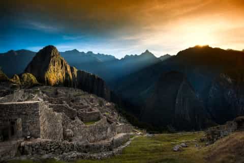 Machu Picchu iluminado por el Sol entre las montañas de los Andes