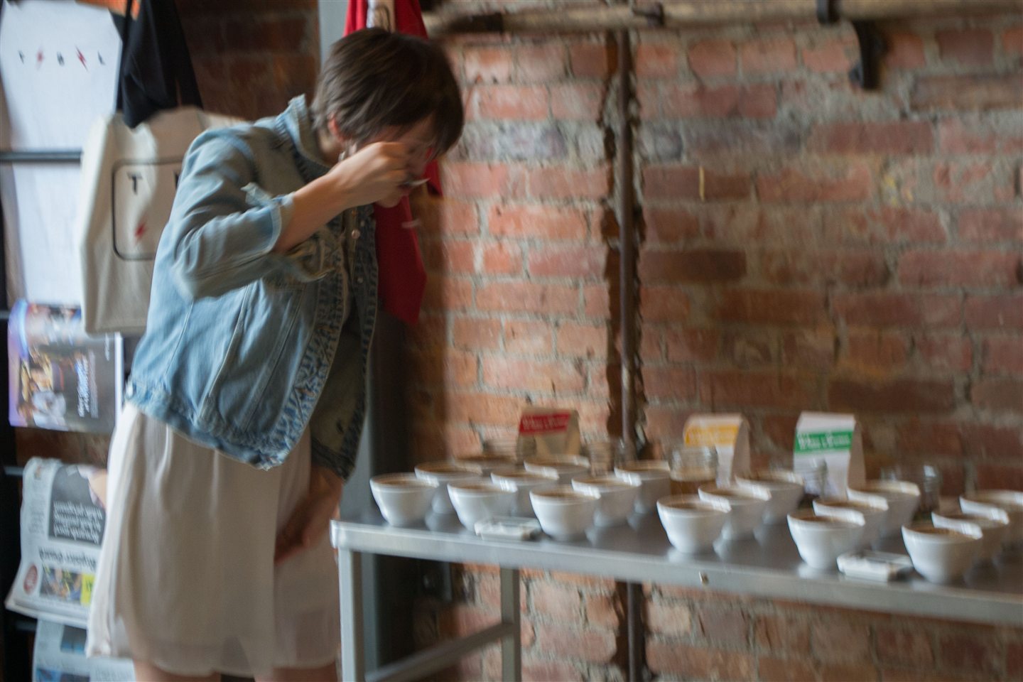 Fotografia real de uma pessoa provando diferentes amostras de café em uma sessão de degustação