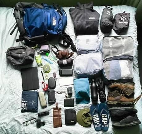 Roupas, calçados, mochila e objetos pessoais organizados antes de um trekking